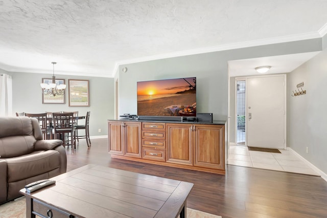 5801 Camino Del Sol Unit 102, Boca Raton, FL 33433 - living area with crown molding, baseboards, light wood-style floors, a notable chandelier, and a textured ceiling