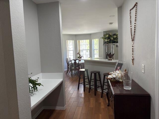 hall featuring wood finished floors and a textured wall