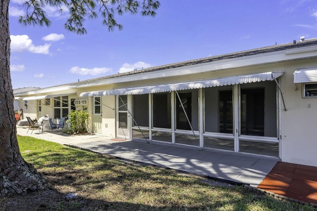 rear view of property featuring a patio area and stucco siding