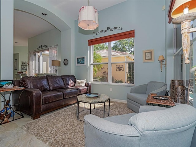 living room featuring baseboards and arched walkways