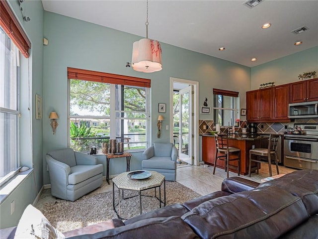 living room with recessed lighting, visible vents, and plenty of natural light