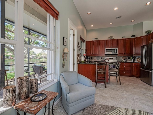 kitchen with dark countertops, visible vents, plenty of natural light, and stainless steel appliances