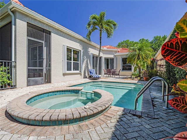 view of swimming pool with a pool with connected hot tub and a patio area