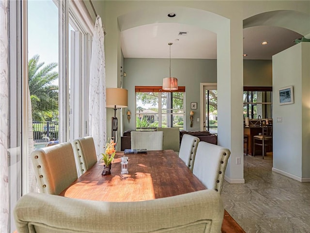 dining space with arched walkways, visible vents, and baseboards