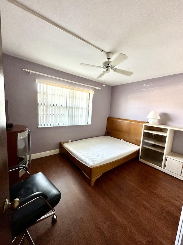 unfurnished bedroom featuring a textured ceiling, baseboards, and a ceiling fan