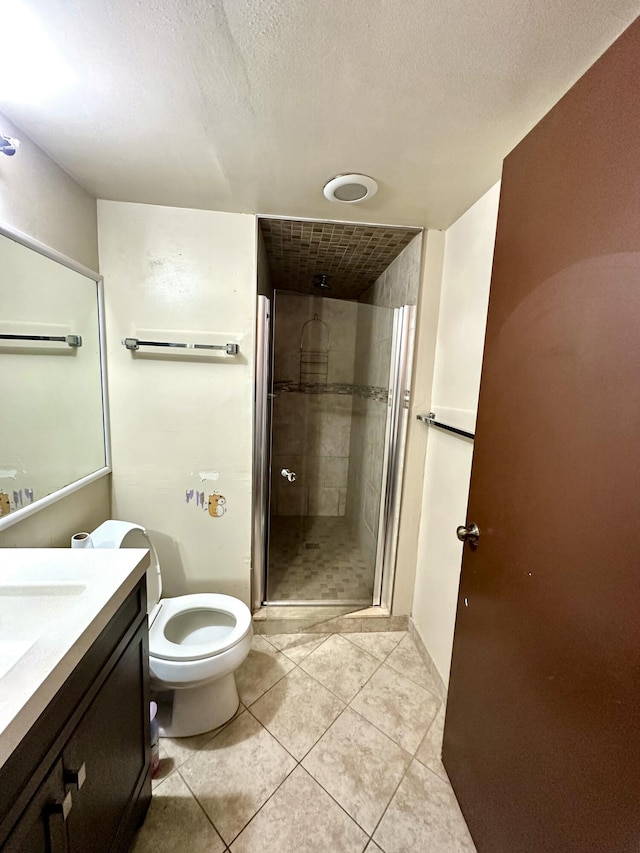 full bathroom with tile patterned flooring, a shower stall, toilet, vanity, and a textured ceiling