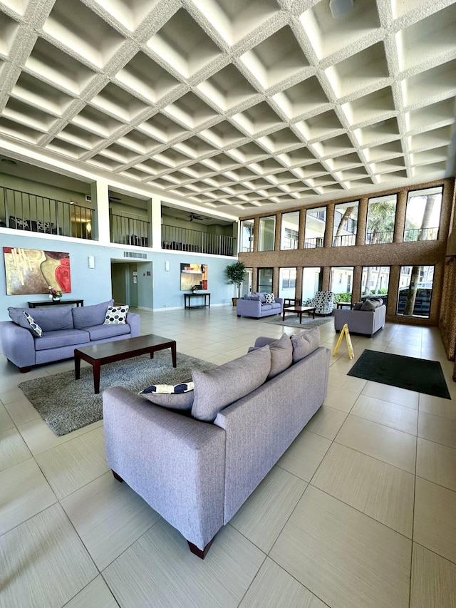 tiled living area with coffered ceiling and a towering ceiling