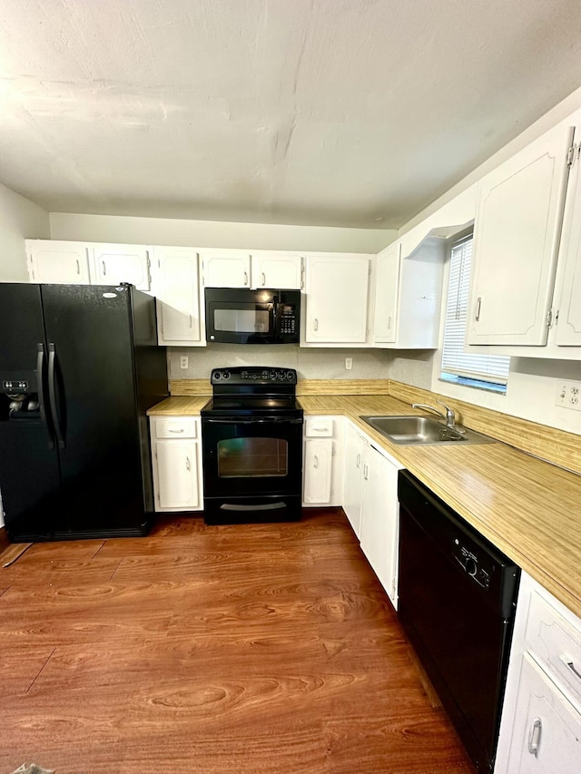 kitchen featuring black appliances, white cabinets, dark wood-style floors, and a sink