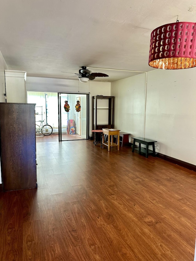 spare room with dark wood finished floors, baseboards, and a ceiling fan