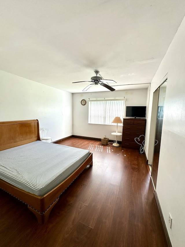 unfurnished bedroom featuring wood finished floors, baseboards, and ceiling fan