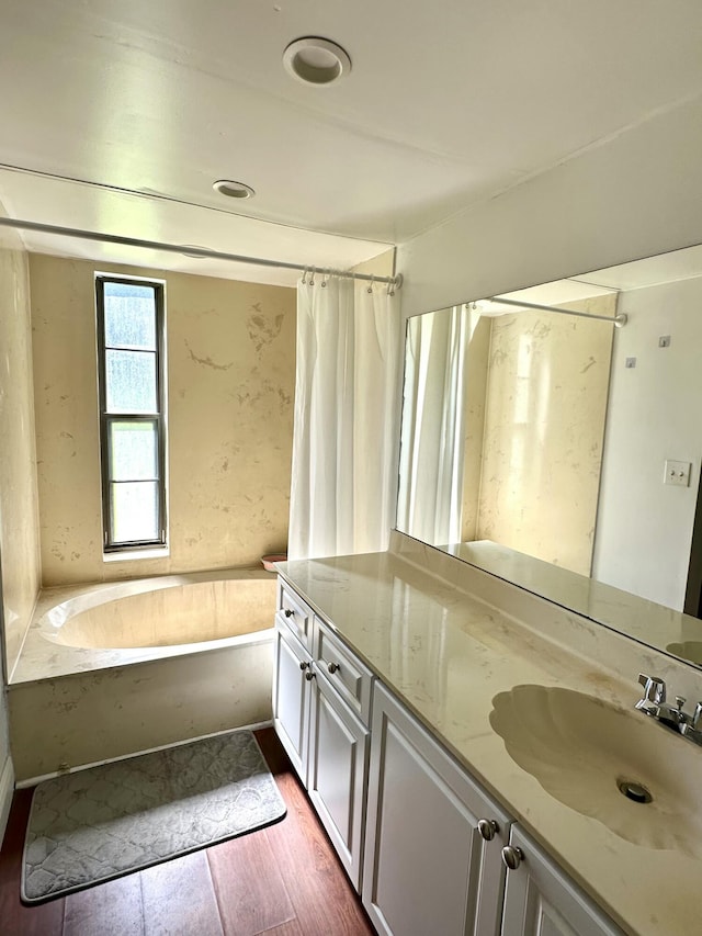 bathroom featuring vanity, a shower with shower curtain, wood finished floors, and a bathtub