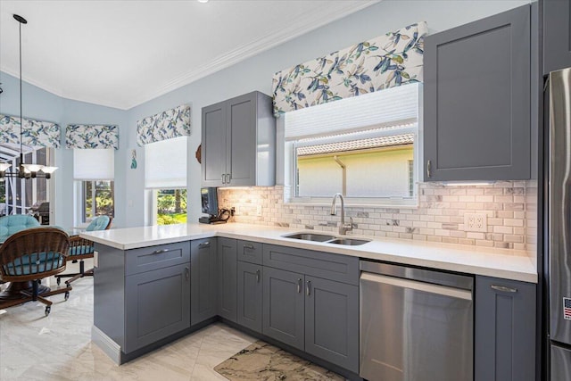 kitchen featuring a peninsula, gray cabinets, appliances with stainless steel finishes, and a sink