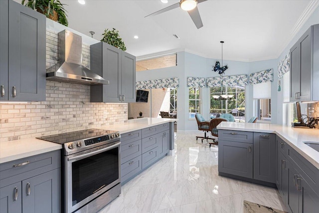 kitchen featuring light countertops, ornamental molding, gray cabinets, stainless steel electric range, and wall chimney exhaust hood