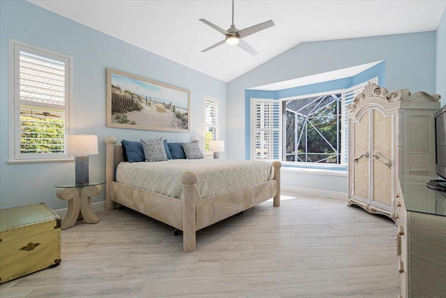 bedroom featuring lofted ceiling, multiple windows, a ceiling fan, and light wood-type flooring