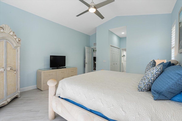 bedroom featuring baseboards, lofted ceiling, light wood-style flooring, ceiling fan, and a closet