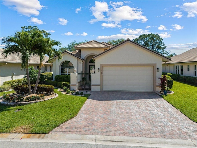 view of front facade featuring a front lawn, a tile roof, stucco siding, decorative driveway, and an attached garage