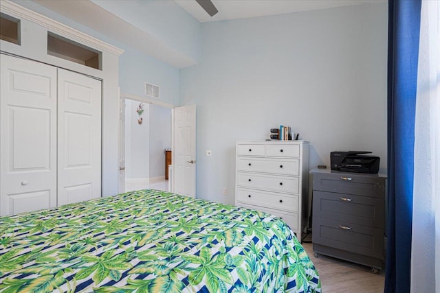 unfurnished bedroom featuring a closet, visible vents, a ceiling fan, and wood finished floors