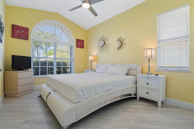 bedroom with ceiling fan, baseboards, lofted ceiling, and light wood-style flooring