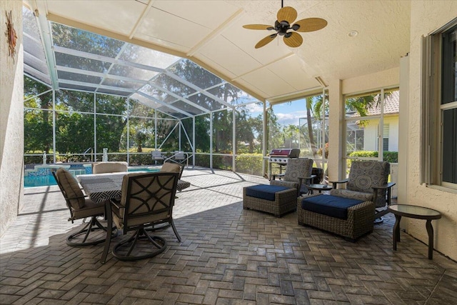 view of patio with an outdoor pool, glass enclosure, and a ceiling fan