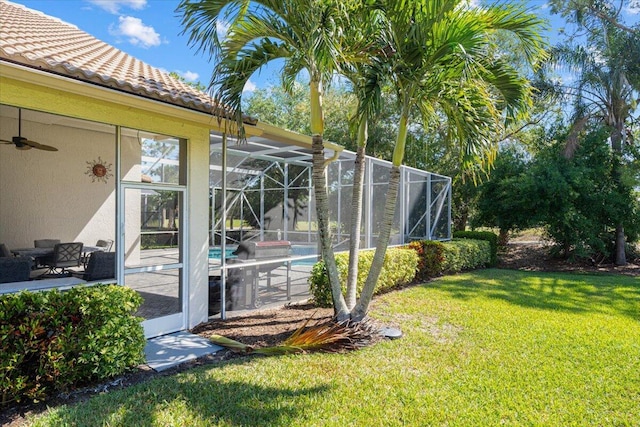 view of yard with glass enclosure, a patio, and an outdoor pool