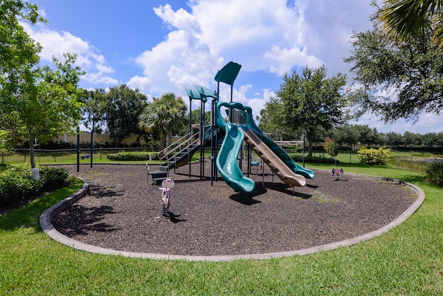 community playground with a yard and fence