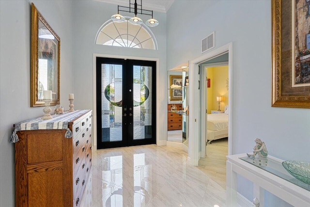 foyer entrance with visible vents, marble finish floor, french doors, and crown molding