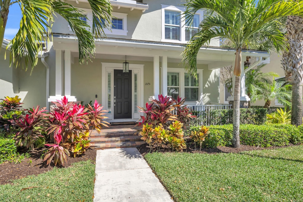 view of exterior entry with covered porch and stucco siding