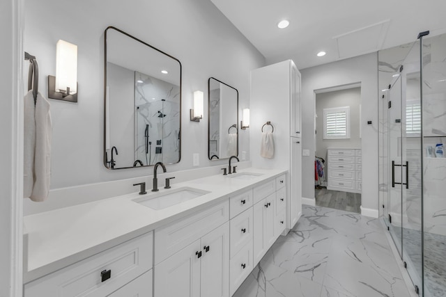 bathroom featuring a marble finish shower, marble finish floor, and a sink