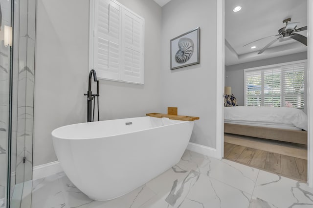 ensuite bathroom with baseboards, recessed lighting, a freestanding bath, ensuite bathroom, and marble finish floor