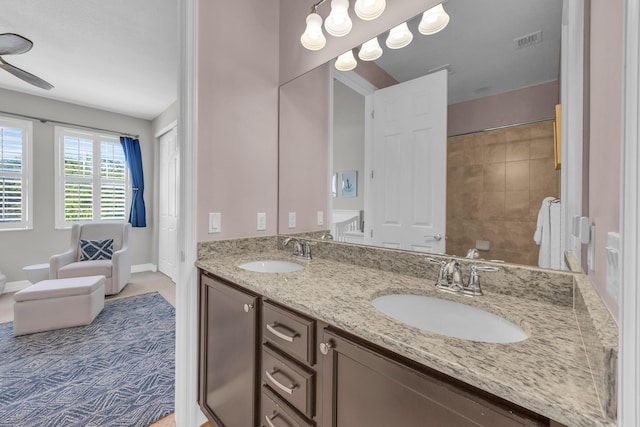 bathroom featuring double vanity, visible vents, baseboards, and a sink