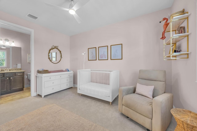 living area with light colored carpet, visible vents, and ceiling fan