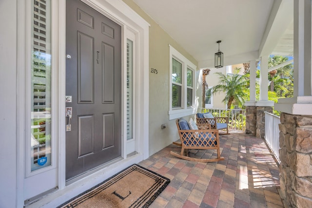 entrance to property with stucco siding and a porch