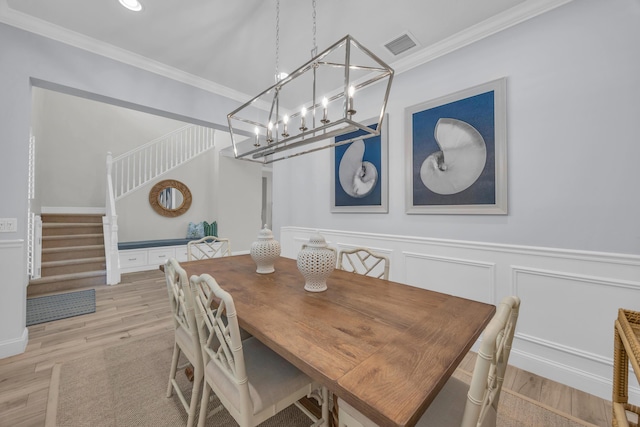 dining area with visible vents, stairs, crown molding, a notable chandelier, and light wood-type flooring