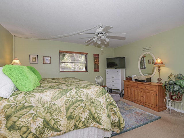 bedroom with a ceiling fan, baseboards, and light carpet