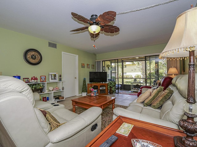 living room featuring tile patterned floors, visible vents, and ceiling fan