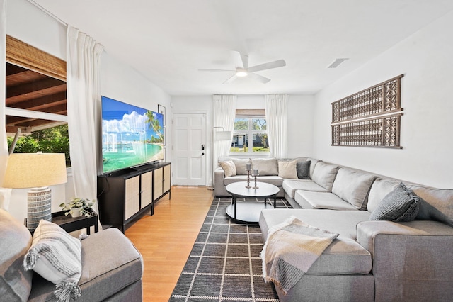 living room with visible vents, ceiling fan, and wood finished floors