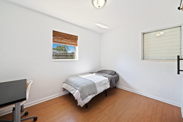 bedroom featuring baseboards and wood finished floors