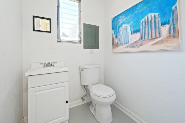 bathroom featuring baseboards, toilet, and vanity