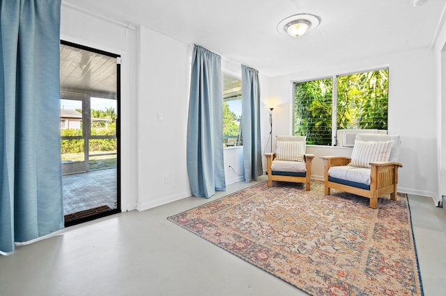 sitting room featuring baseboards and concrete flooring