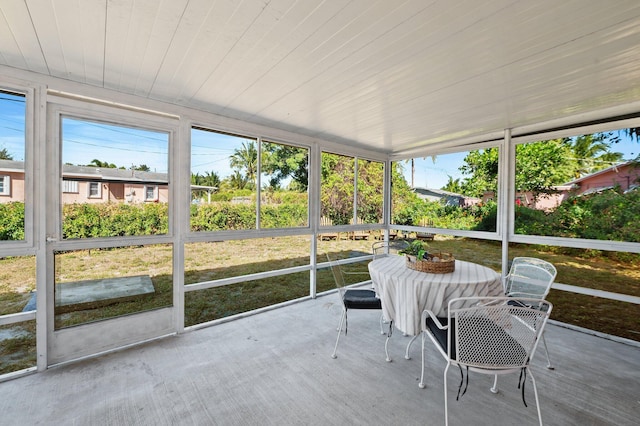 sunroom / solarium featuring a healthy amount of sunlight and wooden ceiling