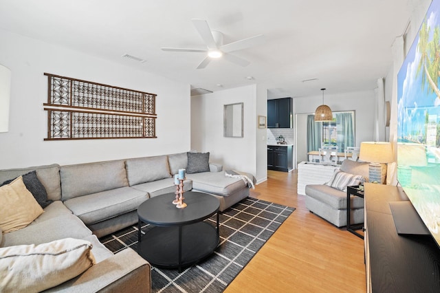 living room with visible vents, a ceiling fan, and wood finished floors