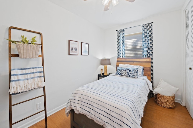 bedroom with ceiling fan, a closet, baseboards, and wood finished floors