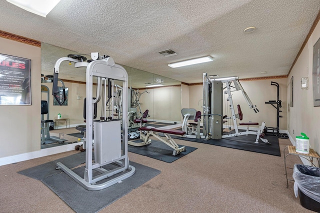 exercise room featuring visible vents, a textured ceiling, and ornamental molding