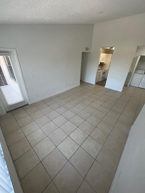 empty room featuring a textured ceiling and light tile patterned flooring