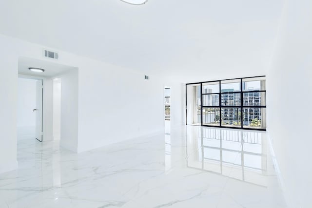 spare room with visible vents, baseboards, and marble finish floor