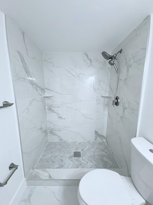 full bath featuring toilet, marble finish floor, and a marble finish shower