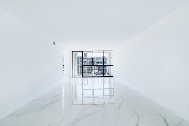 empty room with visible vents, baseboards, and marble finish floor