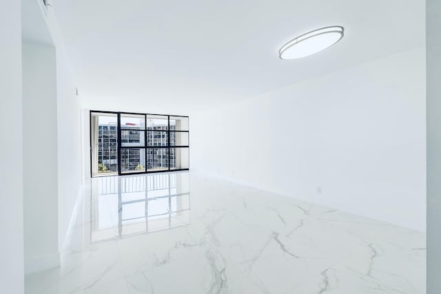 unfurnished room with marble finish floor