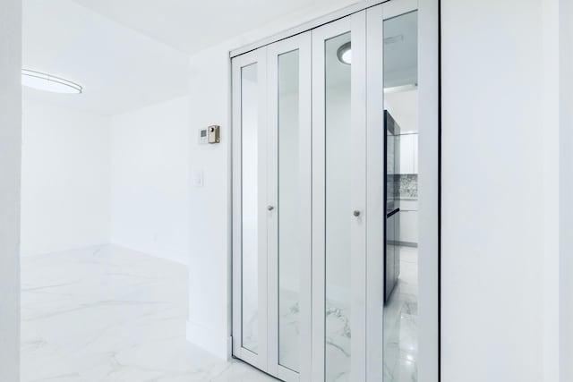 corridor featuring marble finish floor