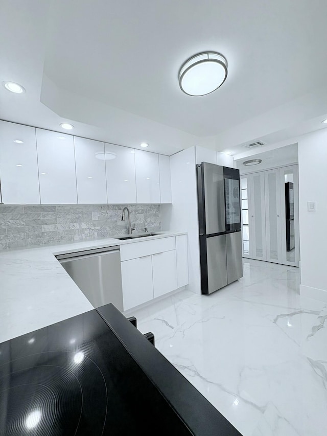 kitchen featuring modern cabinets, marble finish floor, a sink, white cabinetry, and appliances with stainless steel finishes